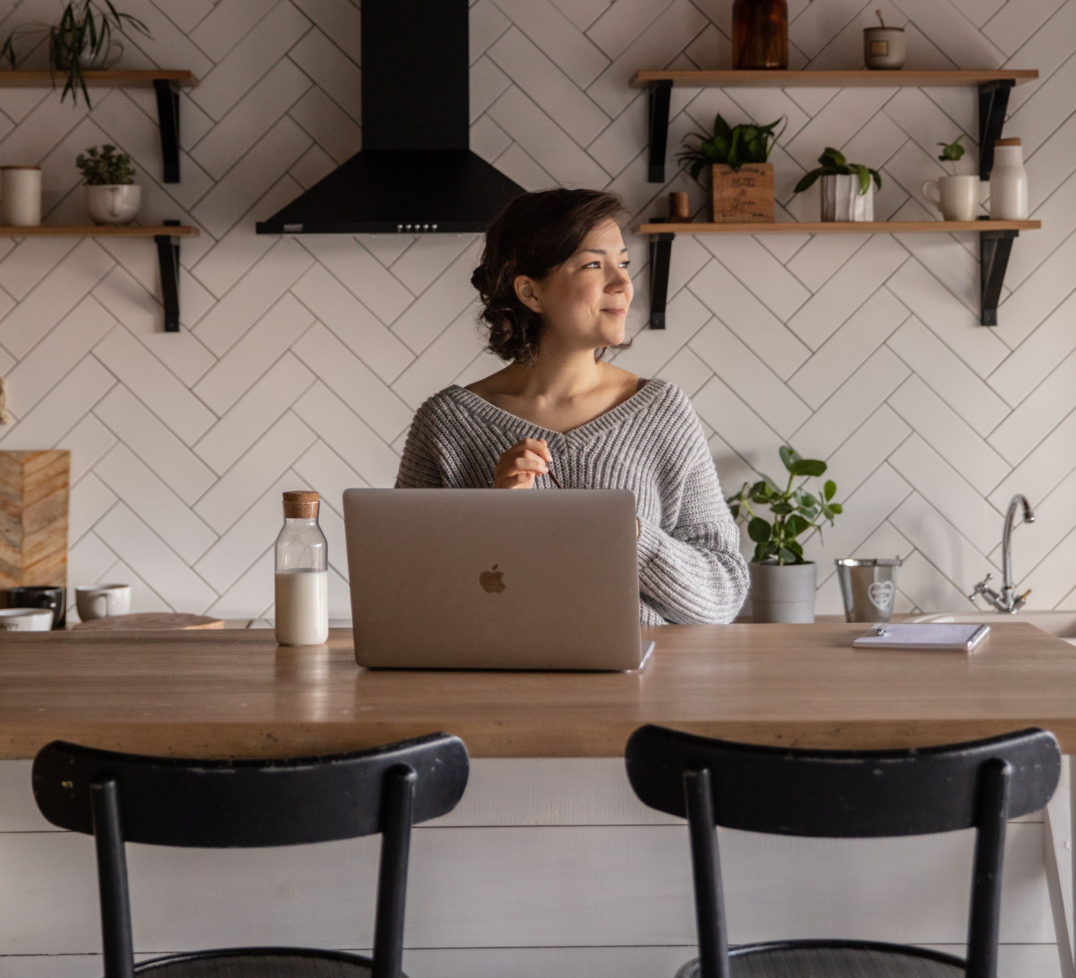 A salon owner at her laptop in a warm kitchen after hours